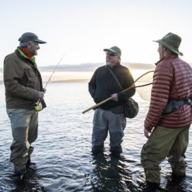 Two fly fisherman talk wtih their guide about new tecnhiques while fly fishing for searun coastal